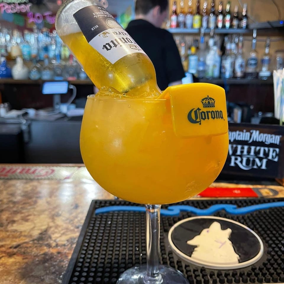 A Corona beer bottle inverted into a large glass of yellow margarita at LA Taco Cantina.